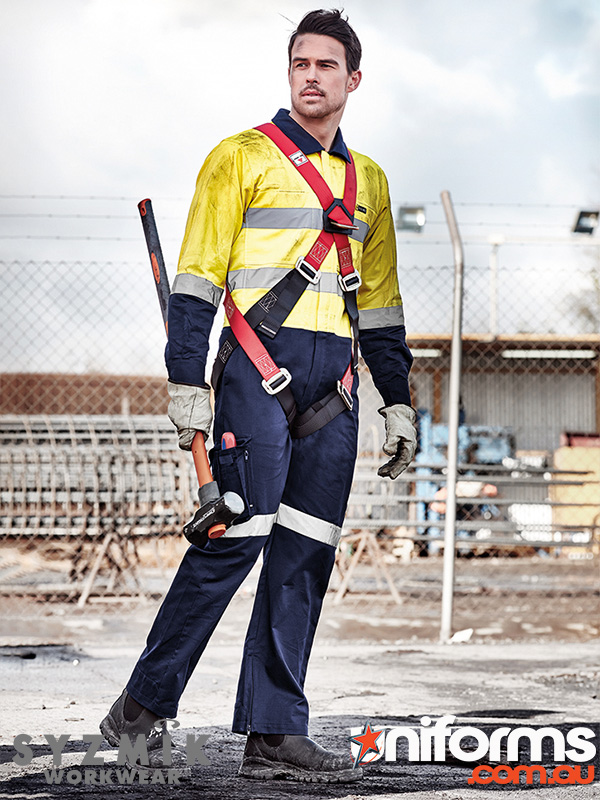 A man standing in a construction site wearing the Syzmic Men’s Rugged Cooling Taped Overall - ZC804.