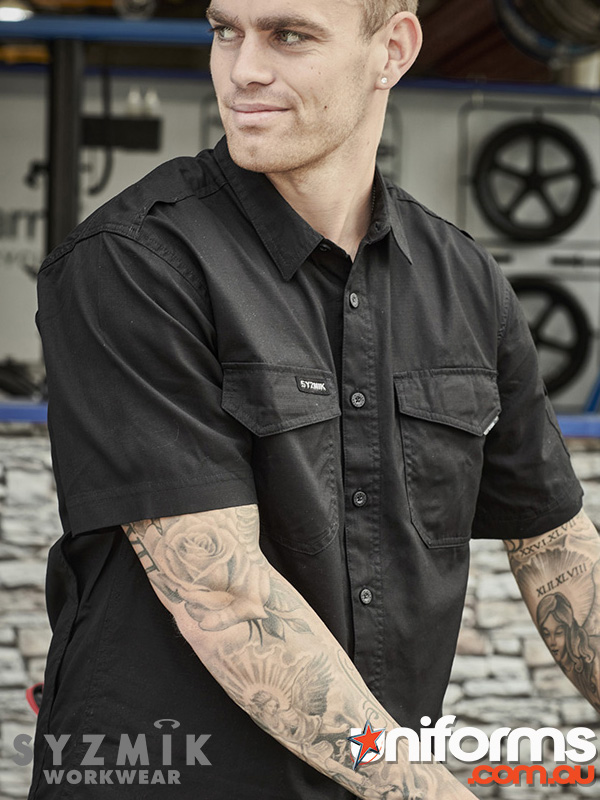 A man with tattooed arms is dressed in a black Syzmic Cooling Shirt shirt ZW400 style.