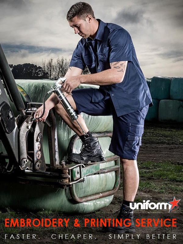 A man in a blue shirt and blue jeans on a tractor, wearing Lightweight Tradie shirt ZW120.