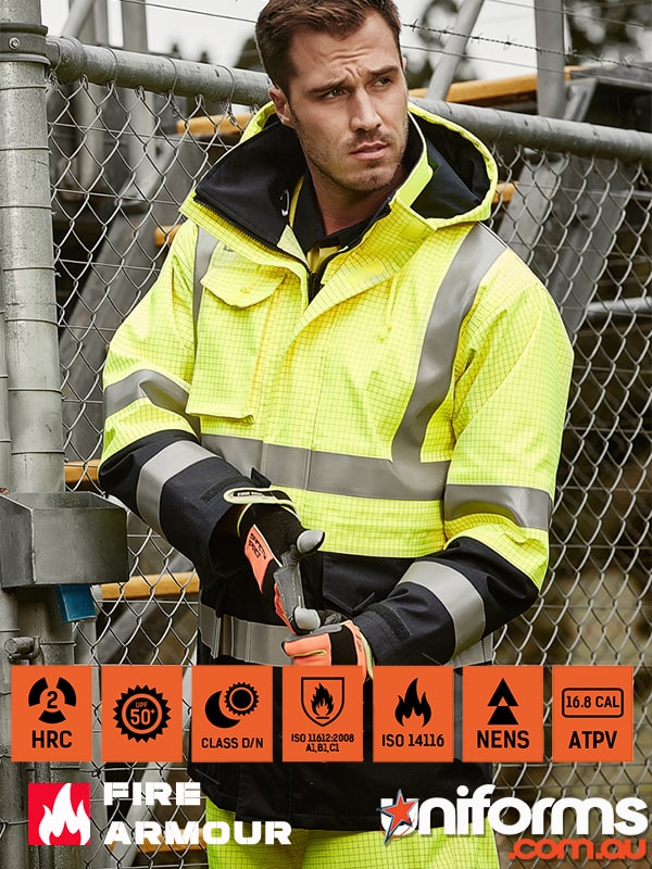 A tradie standing beside a fence showcasing Syzmic ZJ900 Men’s Orange Flame Arc Rated Antistatic Waterproof Jacket 